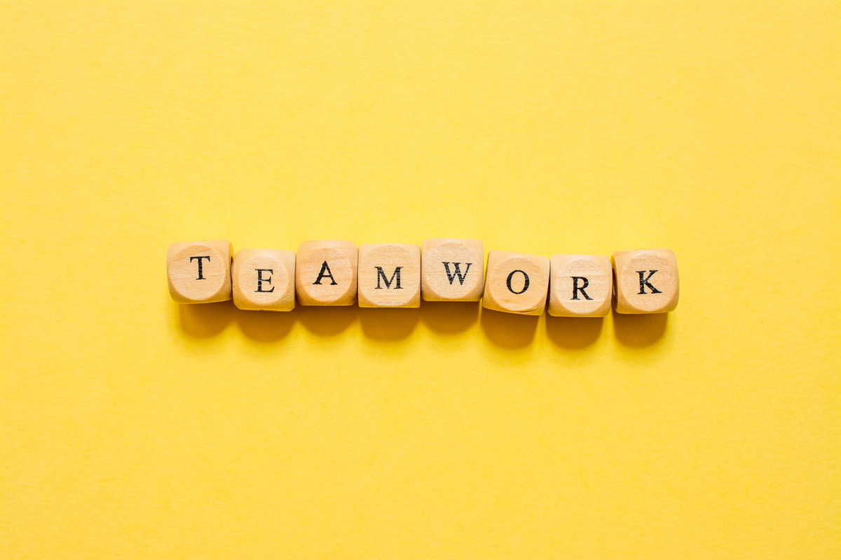 the word Teamwork, text made with dice on yellow background