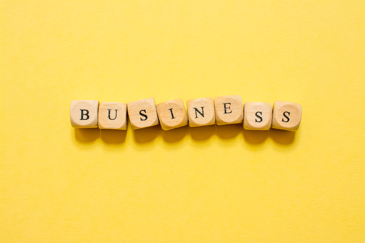 the word Business, text made with dice on yellow background